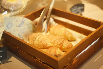 Croissants on a basket weave in a bakery shop. Fresh butter croissants