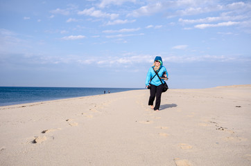 Lone woman hiker on Race Point beach, walks alone in the sand on Cape Cod National Seashore in Provincetown