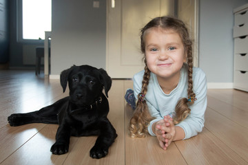 Little smiling baby kid and puppy Labrador retriever.
