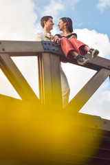 Pareja de novios se miran apasionadamente, llenos de amor, en mitad de un puente de madera