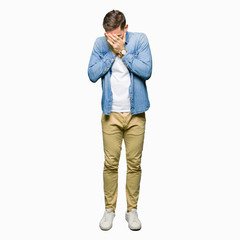 Naklejka premium Handsome man with blue eyes and beard wearing denim jacket with sad expression covering face with hands while crying. Depression concept.