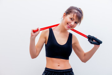 adult girl in sport clothes with expander on white background.