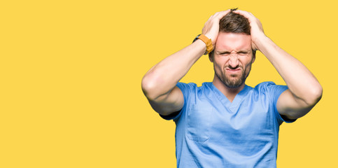 Fototapeta na wymiar Handsome doctor man wearing medical uniform over isolated background suffering from headache desperate and stressed because pain and migraine. Hands on head.