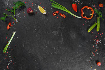 Selection of spices herbs and greens. Ingredients for cooking. Food background on black slate table. Top view copy space.