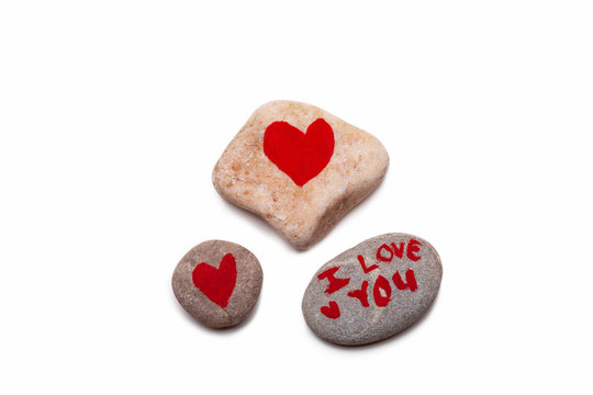 Three pebbles, two with painted red hearts and wone with I LOVE YOU painted on it