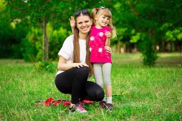 Mother and little daughter playing together in park. Outdoor Portrait of happy family. Happy...