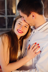 The girl looks into the camera lens and leaned to the guy. on he