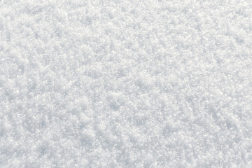 Fresh fluffy snow texture in the sun. Winter background with top view closeup