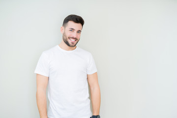 Obraz premium Young handsome man wearing casual white t-shirt over isolated background looking away to side with smile on face, natural expression. Laughing confident.