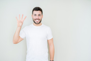 Young handsome man wearing casual white t-shirt over isolated background showing and pointing up with fingers number four while smiling confident and happy.