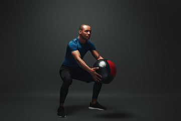 Test yourself. Young sportsman standing over dark background with a ball in his hands