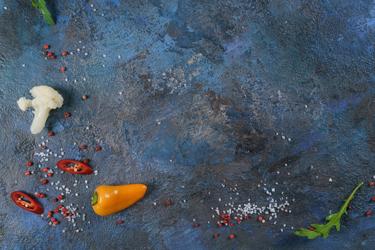 Selection of spices herbs and greens. Ingredients for cooking. Food background on blue nable. Top view copy space.