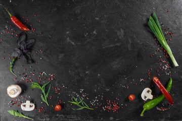 Selection of spices herbs and greens. Ingredients for cooking. Food background on black slate...