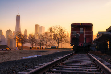 Fototapeta premium Golden sunrise over Liberty State Park, Featuring abandoned railroad tracks on the foreground and New York City skyline on the background. High dynamic range photography