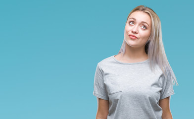 Obraz premium Young blonde woman over isolated background smiling looking side and staring away thinking.