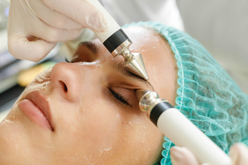 Obraz na płótnie Canvas Cosmetologist makes the procedure microcurrent therapy beauty salon
