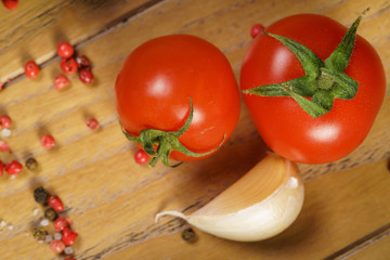 Cherry tomatoes on branch and spice on a wooden background. Copy space. Food background.