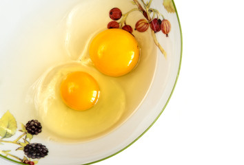 Raw egg yolks in the plate isolated on white background, top view.