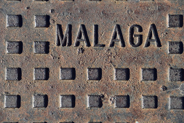 The cover of the well with the Malaga sign. - obrazy, fototapety, plakaty