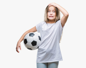 Young beautiful girl holding soccer football ball over isolated background stressed with hand on...