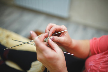 Close-up of woman hands knits wool stockings.