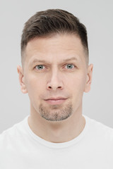 Obraz premium Futuristic handsome bearded brunet man 40s years in white clothes on a white background close-up. God, teacher and boss.