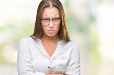 Young caucasian beautiful business woman wearing glasses over isolated background skeptic and...