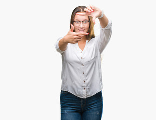 Fototapeta premium Young caucasian beautiful business woman wearing glasses over isolated background smiling making frame with hands and fingers with happy face. Creativity and photography concept.