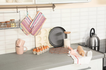 Set of clean cookware, utensils and products on table in modern kitchen
