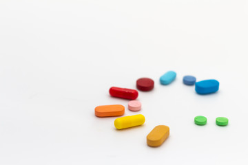 Circle of colored pills on white background. Legal drugs from the pharmaceutical industry.