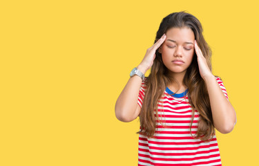 Young beautiful brunette woman wearing stripes t-shirt over isolated background with hand on head for pain in head because stress. Suffering migraine.