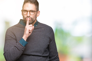 Young handsome man wearing glasses over isolated background asking to be quiet with finger on lips. Silence and secret concept.