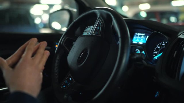 Man driving in innovative automated car using self-parking autopilot for parking on street