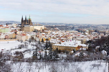 Obraz premium Snowy Prague City with gothic Castle from Hill Petrin in the sunny Day, Czech republic