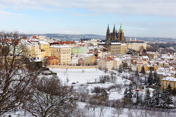 Obraz premium Snowy Prague City with gothic Castle from Hill Petrin in the sunny Day, Czech republic