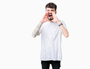 Young handsome man wearing white t-shirt over isolated background Shouting angry out loud with hands over mouth