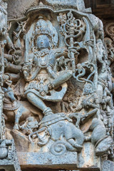 Halebidu, Karnataka, India - November 2, 2013: Hoysaleswara Temple of Shiva. Statue on side of main sanctuary, where Lord Shiva as Gajasurasamhara, killer of elephant demon, dances on head of animal.