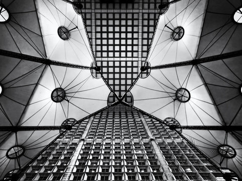 Architectural construction with symmetrical shapes, in La Defence, Paris. looking up