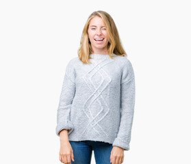 Beautiful young woman wearing winter sweater over isolated background winking looking at the camera...