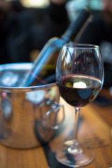 red wine in a glass and bottle with ice bucket