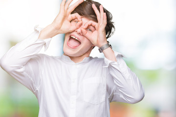 Young handsome business man over isolated background doing ok gesture like binoculars sticking tongue out, eyes looking through fingers. Crazy expression.