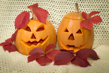 two amusing pumpkins in a crimson autumn leaf
