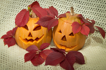 two amusing pumpkins in a crimson autumn leaf