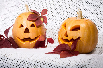 two amusing pumpkins in a crimson autumn leaf
