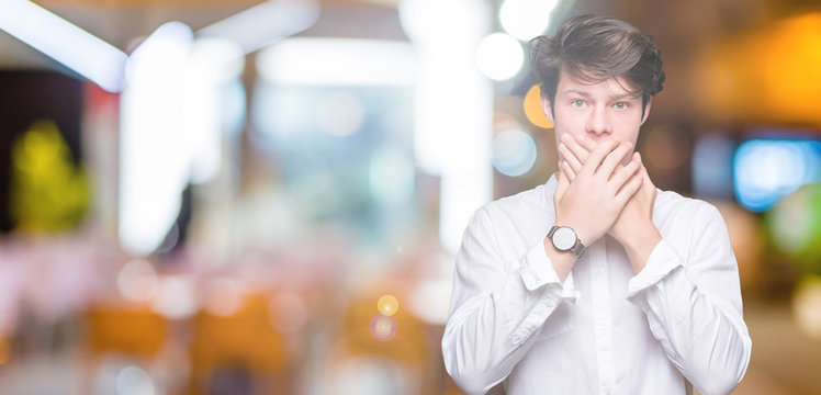 Young handsome business man over isolated background shocked covering mouth with hands for mistake. Secret concept.