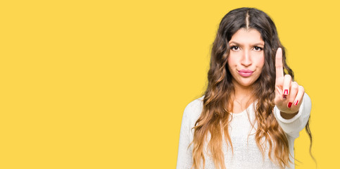 Young beautiful woman wearing white sweater Pointing with finger up and angry expression