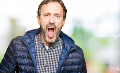 Fototapeta premium Middle age handsome man wearing winter coat In shock face, looking skeptical and sarcastic, surprised with open mouth