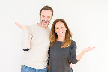 Beautiful middle age couple in love over isolated background Smiling showing both hands open palms, presenting and advertising comparison and balance