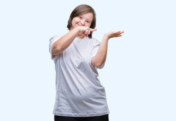 Young adult woman with down syndrome over isolated background amazed and smiling to the camera...