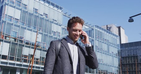 Businessman Talking on Phone Walking on Street of Business District using Mobile Phone. Shot on RED Cinema Camera in 4K - Powered by Adobe